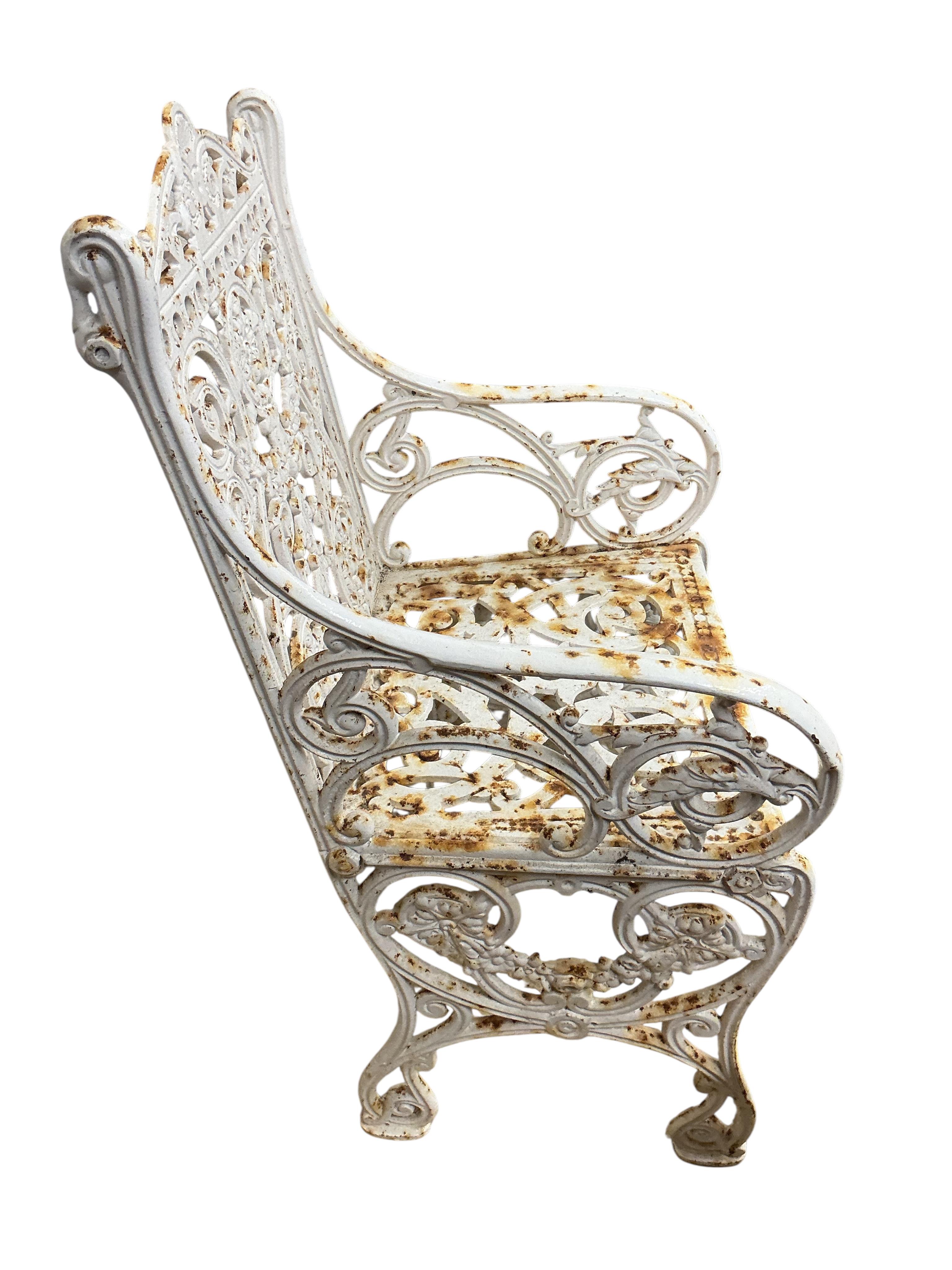 A Victorian Coalbrookdale style painted cast iron garden elbow chair, width 46cm, depth 38cm, height 88cm